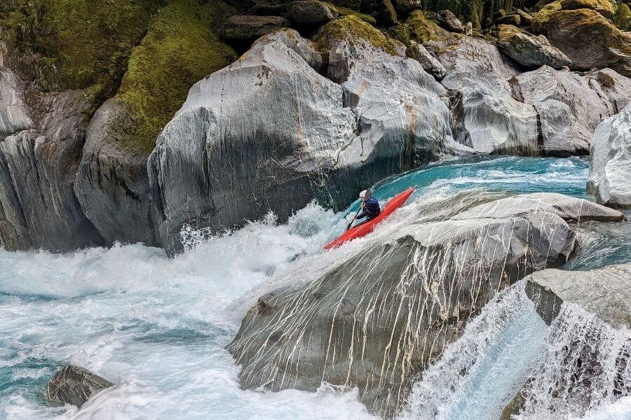 Kayaker on river rapids in Whataroa West Coast New Zealand